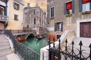 a canal with a gondola in the water between buildings at Charming House Iqs in Venice