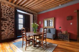 a dining room with red walls and a table and chairs at CASA SAUTO Romantic Suite Cathedral Views in Mexico City