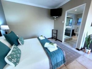 a bedroom with a large white bed with blue pillows at Tropical Seaside Suite 14 in East London
