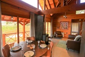 a dining room with a table and chairs and a living room at Tenuta Bergamaschi in São Joaquim