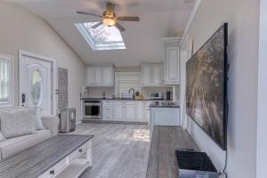 a kitchen with white cabinets and a ceiling fan at Beach cottage villa in Baiting Hollow