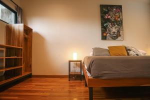 a bedroom with a bed and a painting on the wall at El Hábita CASA SELVA in Santa Teresa Beach