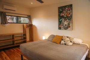 a bedroom with a bed and a painting on the wall at El Hábita CASA SELVA in Santa Teresa Beach