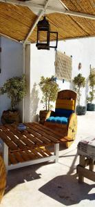 a wooden bench sitting under a pavilion with two trees at l' Escapade 