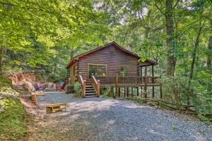 une cabane en rondins dans les bois avec une terrasse couverte dans l'établissement Bigfoots Hideout in Blue Ridge with Hot Tub!, à Blue Ridge