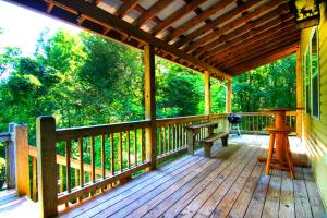 una veranda in legno con panchina di Cozy Cabin Retreat - Hot Tub, Fireplace & Fire Pit a Blue Ridge