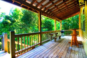 a wooden porch with a bench on it at Cozy Cabin Retreat - Hot Tub, Fireplace & Fire Pit in Blue Ridge