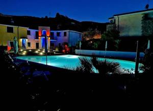 uma grande piscina à noite com luzes acesas em Sardegna Holiday house em Santa Maria