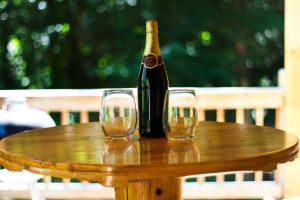 a bottle of wine and two glasses on a wooden table at Cozy Cabin Retreat - Hot Tub, Fireplace & Fire Pit in Blue Ridge +23 photos