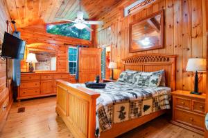 een slaapkamer met een bed in een blokhut bij Cozy Cabin Retreat - Hot Tub, Fireplace & Fire Pit in Blue Ridge