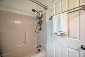 a white bathroom with a shower and a bath tub at Airy and Bright Hideaway Near Smugglers Notch! in Cambridge +16 photos
