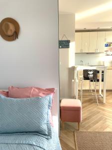 Cet appartement comprend une chambre avec un lit et une cuisine avec une table. dans l'établissement Apartament Lenka, à Dziwnówek