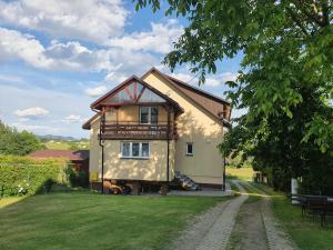 uma pequena casa com um alpendre em cima em Noclegi u Kazi em Polańczyk