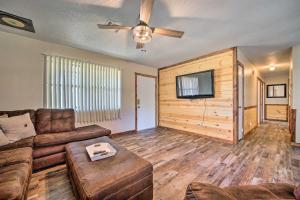 a living room with a couch and a flat screen tv at Broken Bow Vacation Rental with Private Hot Tub! in Broken Bow