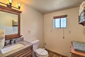 a bathroom with a toilet and a sink and a mirror at Deck, Porch and Grill Heber-Overgaard Getaway! in Heber +18 photos