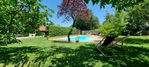 リリューにあるExclusif - Splendide villa 6ch à 15min de Lyonのスイミングプールと椅子2脚付きの庭