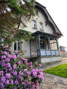 une maison avec des fleurs violettes devant elle dans l'établissement Vila Bohemia Saxon Switzerland, à Šluknov