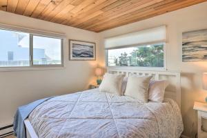 a bedroom with a large bed with two windows at Waterfront Ferndale Home Deck and Beach Access in Ferndale