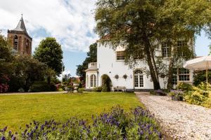 an exterior view of a white house with a garden at Fortuna Spinoza in Monnickendam