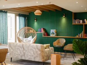 sala de estar con sofá y pared verde en Best Western Le Bois de la Marche, en Poitiers