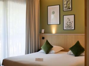 a hotel room with a bed and a window at Best Western Le Bois de la Marche in Poitiers