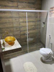 a bathroom with a shower with a toilet and a sink at Village Colonial Pousada in Penedo