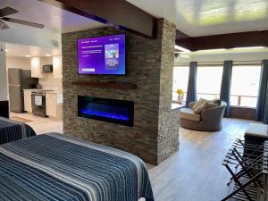 a room with a fireplace with a tv on a brick wall at 1,000 Springs Riverhouse in Hagerman