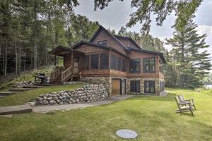 a log home with a deck and a yard at Waterfront Star Lake Cabin, Boat Dock On-Site in Sayner