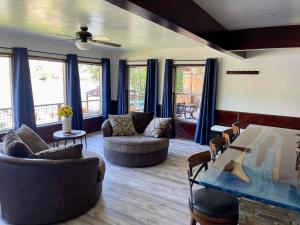 a living room with couches and chairs and windows at 1,000 Springs Riverhouse in Hagerman