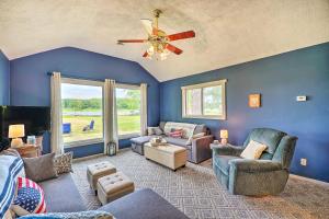 ein Wohnzimmer mit blauen Wänden und einem Deckenventilator in der Unterkunft Cottage on Tubbs Lake with Kayaks, Grill and Fire Pit! in Mecosta