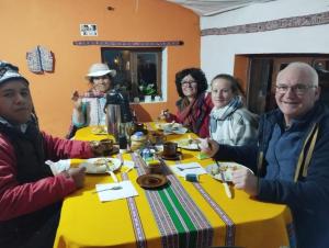 a group of people sitting around a table eating food at Casa vivencial Mamá Vivi in Coporaque +183 photos