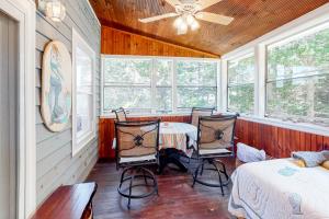 1 dormitorio con mesa, 2 sillas y ventanas en Maine Haven, en Phippsburg