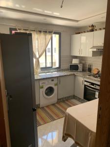a kitchen with a washing machine and a window at Appartement avec piscine et proch de plage in Kenitra