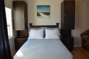 a bedroom with a bed with two nightstands and a bed sidx sidx sidx at Le Citadin in Rouyn