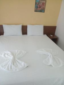 uma cama branca com duas toalhas brancas em Flat no ancorar flat resort em Porto de Galinhas