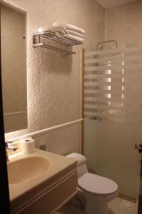 bagno con lavandino, servizi igienici e specchio di فندق وايت مون للأجنحة الفندقية a Khamis Mushayt