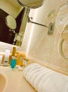 uma casa de banho com um chuveiro, um lavatório e um espelho. em فندق وايت مون للأجنحة الفندقية em Khamis Mushayt