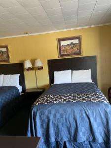 a hotel room with a bed and two lamps at Budget Inn in Monroeville