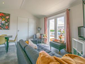 sala de estar con sofá azul y ventana en Grote Karekiet 24-30 en Breukelen