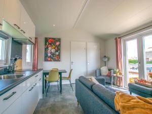 a kitchen and living room with a couch and a table at Grote Karekiet 24-30 in Breukelen