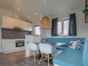 cocina y sala de estar con sofá azul y mesa en Purperreiger 24-34, en Breukelen