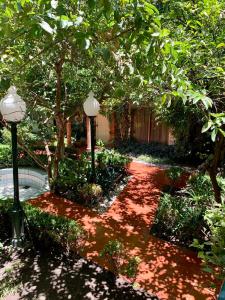 un jardín con una pasarela de ladrillo rojo con dos luces en Hotel Inn Galerias, en Aguascalientes