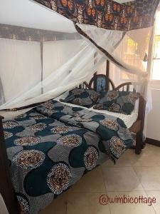 Кровать или кровати в номере Wimbi Cottage