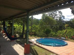 a patio with a hammock and a swimming pool at NUEVO- Finca La Belleza-Villeta in Villeta