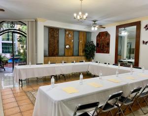 a room with tables with white table cloths and chairs at Hotel Inn Galerias in Aguascalientes