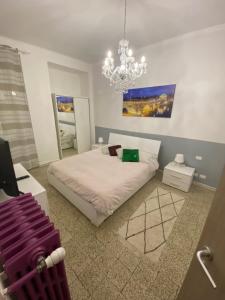 ein Schlafzimmer mit einem weißen Bett und einem Kronleuchter in der Unterkunft Appartamenti Mazzini in Turin