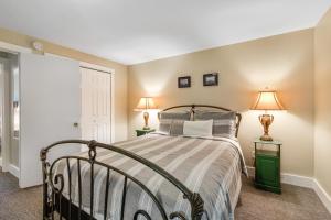 a bedroom with a bed with two lamps on two tables at Cake by the Ocean in Clinton