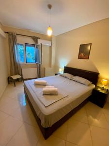 a bedroom with a large bed with two towels on it at Quiet apartment in Artemis, Athens Airport in Artemida