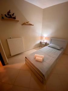 a bedroom with a bed with two towels on it at Quiet apartment in Artemis, Athens Airport in Artemida +2 photos