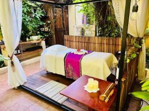 een kamer met een bed en een tafel met een tafel sidx sidx bij Hacienda Boutique B&B and Spa Solo Adultos in Cozumel
